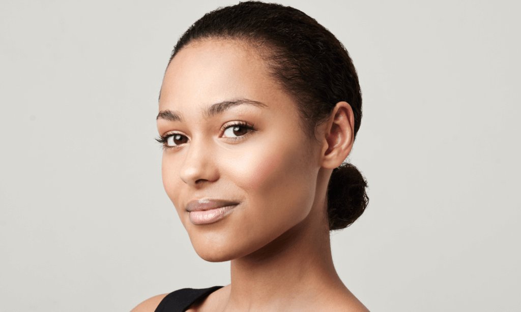 woman slightly smiling at the camera against a white background